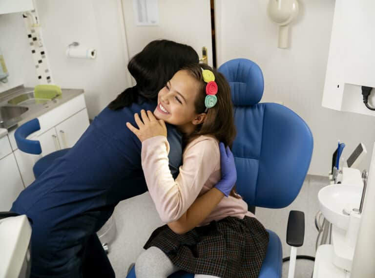 Staff member hugging a patient after she finishes her orthodontic treatment