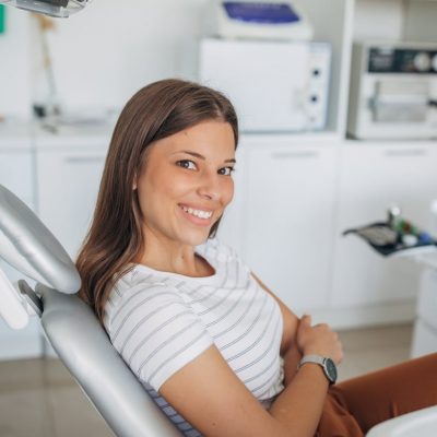 One woman, young lady sitting in dentist's chair.