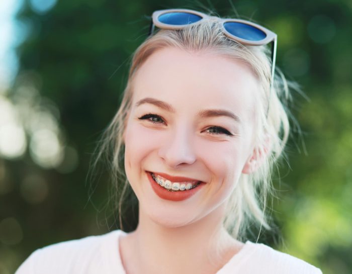 beautiful blond teen girl with braces on her teeth smiling