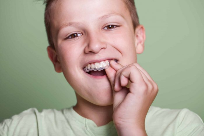 Boy wearing a mouth guard that protects from teeth grinding at night