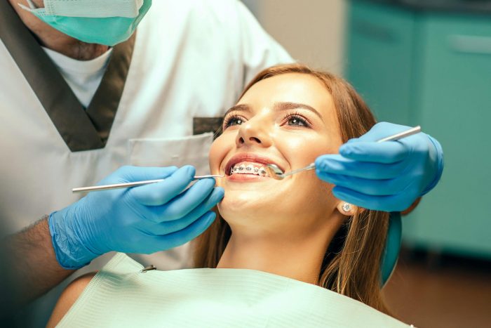 Dentist,Examine,Female,Patient,With,Braces,In,Denal,Office