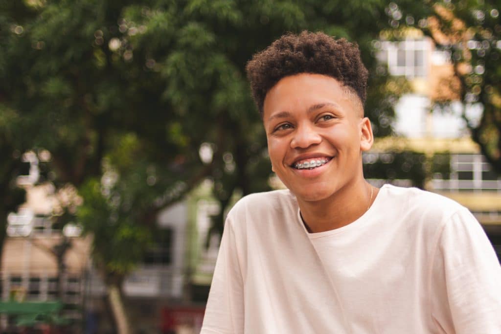 a young man smiling to show his braces