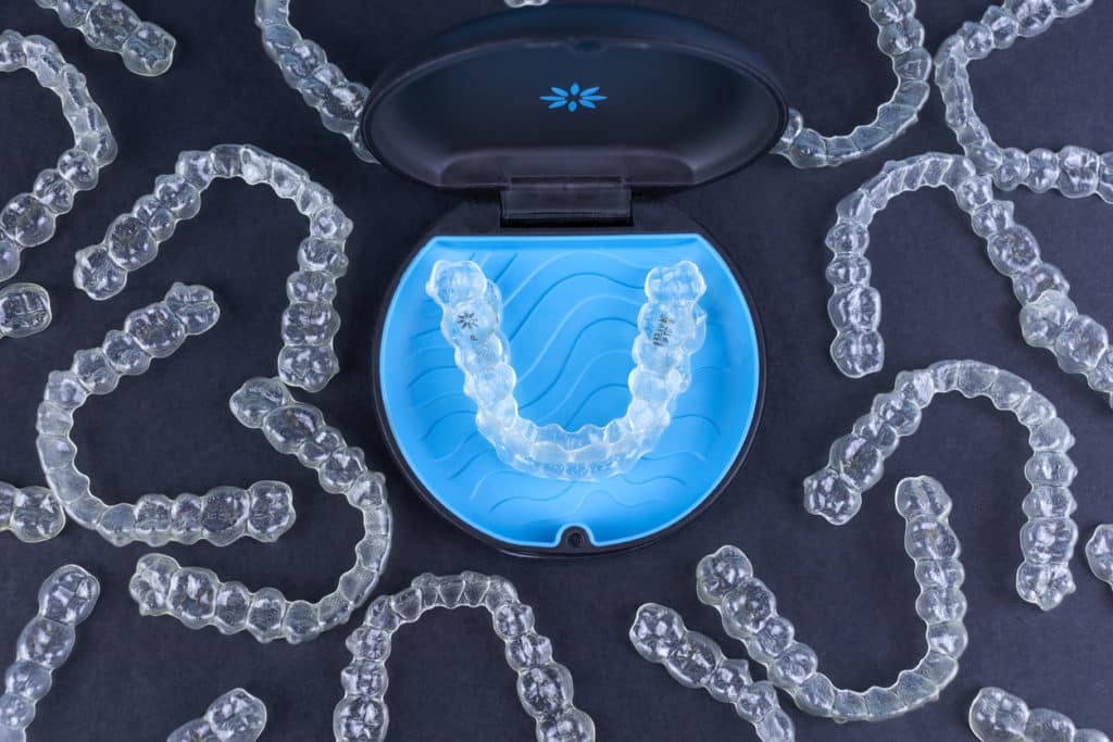 top view of many invisalign clear aligners and their holding case