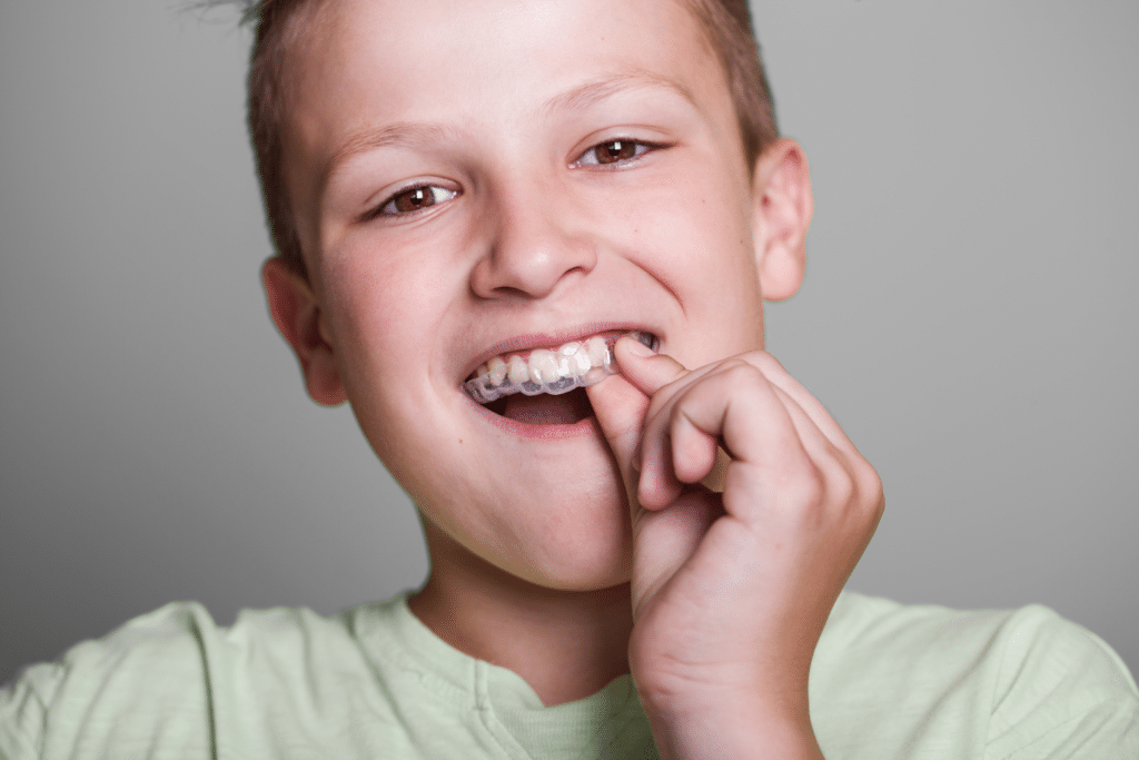 Young teenager inserting Invsialign Teen® clear aligner in Hendersonville, TN